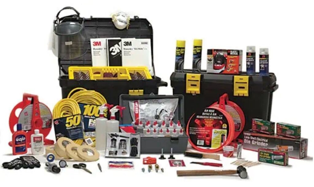 A collection of various automotive detailing and repair supplies, including cleaning products, polishes, waxes, sponges, cables, and tools—essential for anyone undergoing PDR Training in California—are placed in and around two black and yellow toolboxes.