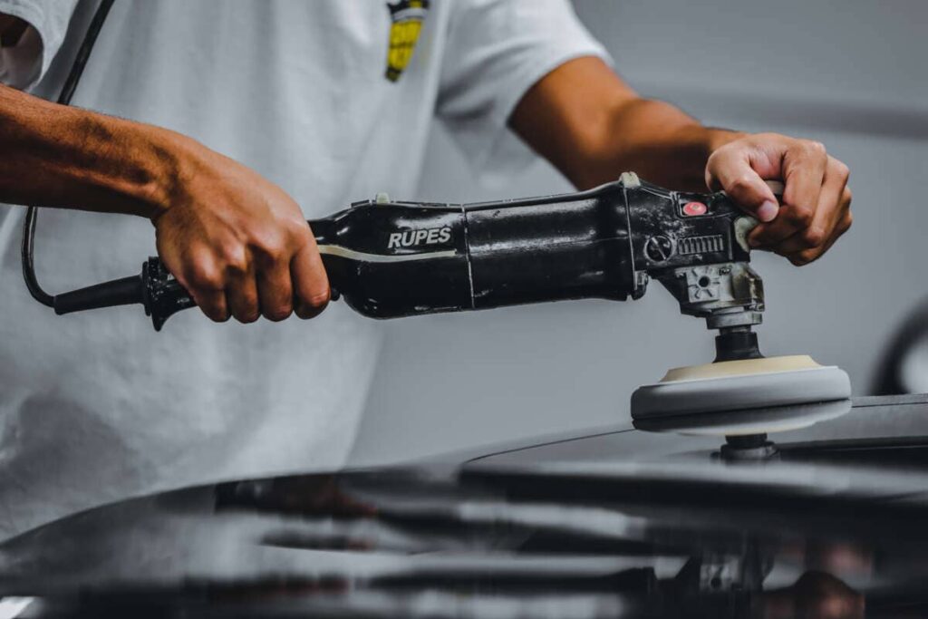 A person using a Rupes power tool to polish or buff the surface of a vehicle during PDR Training in California.