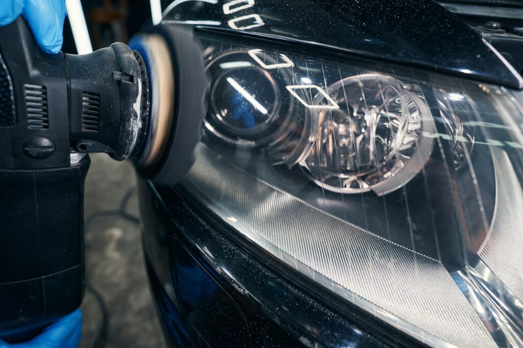 Headlight polishing with orbital sander on repair shop