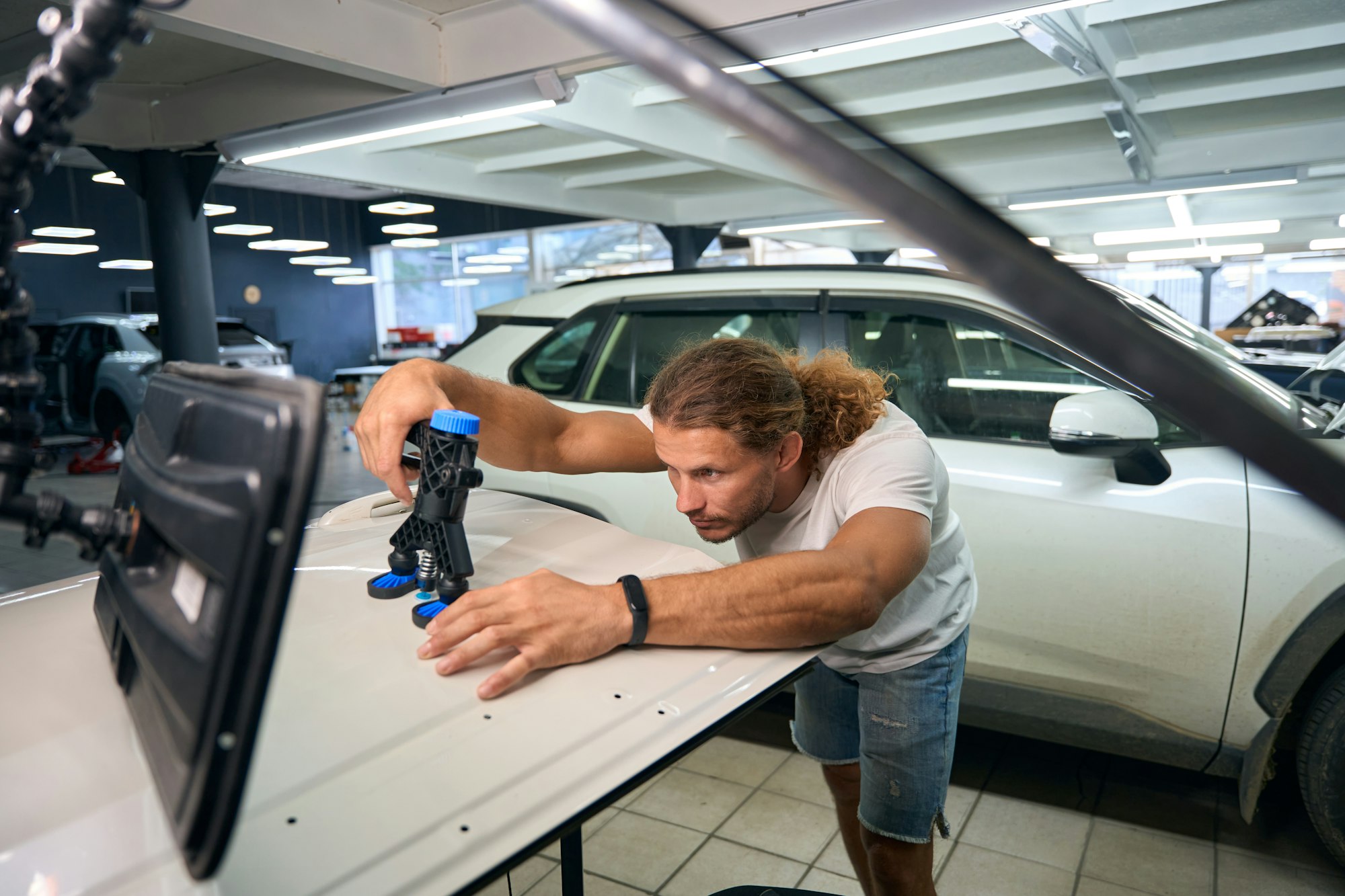 Long-haired guy uses a straightening pump at work