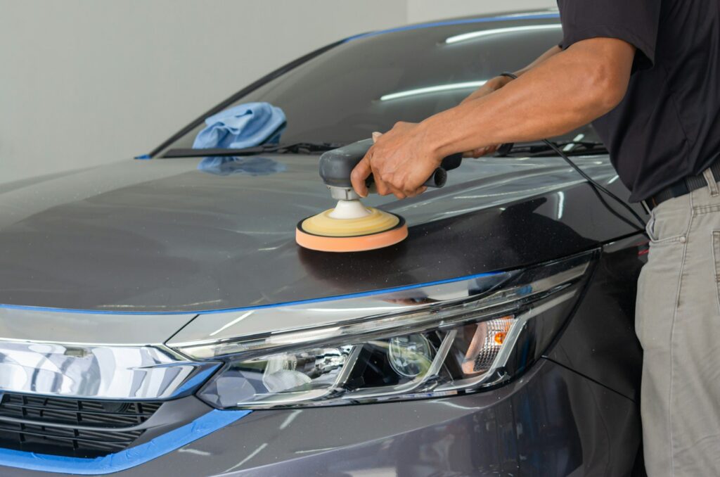 Car detailing - Male mechanic holding car polishing machine. Auto industry,