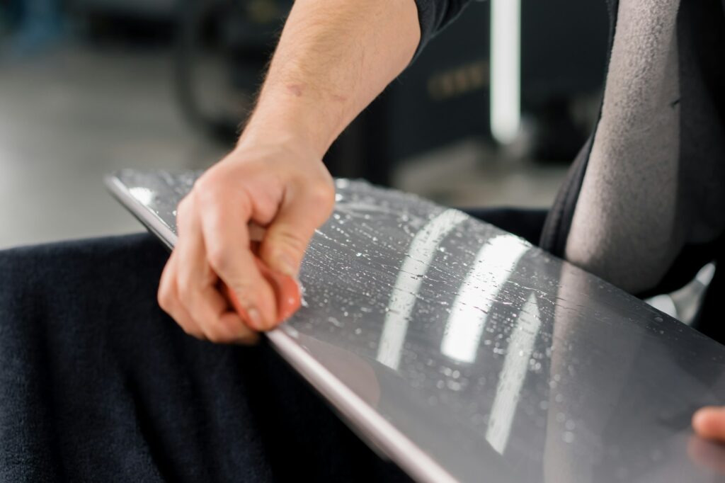 Preparation of a car spoiler for gluing a paint protection film that protects the paint